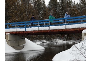 Skieurs sur le pont enjambant la Rivière-Bleue.